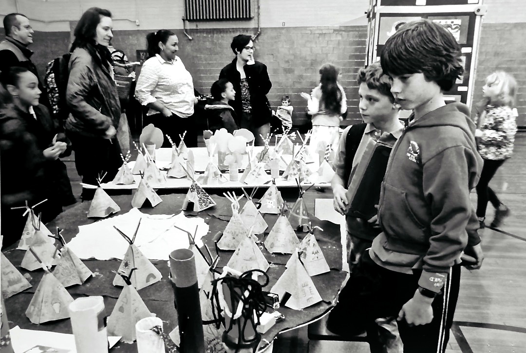 Families viewing student artwork at a schoolwide visual arts showcase