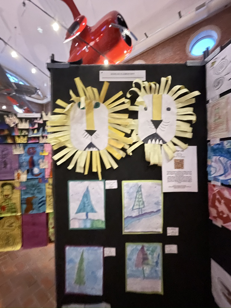 Colorful student mixed-media artwork installed together on an exhibition panel